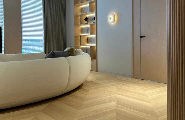 Wandbündige Tür mit verdeckter Zarge neben Chevron-Parkett